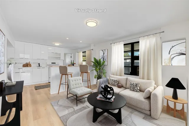 a living room with furniture kitchen view and a window