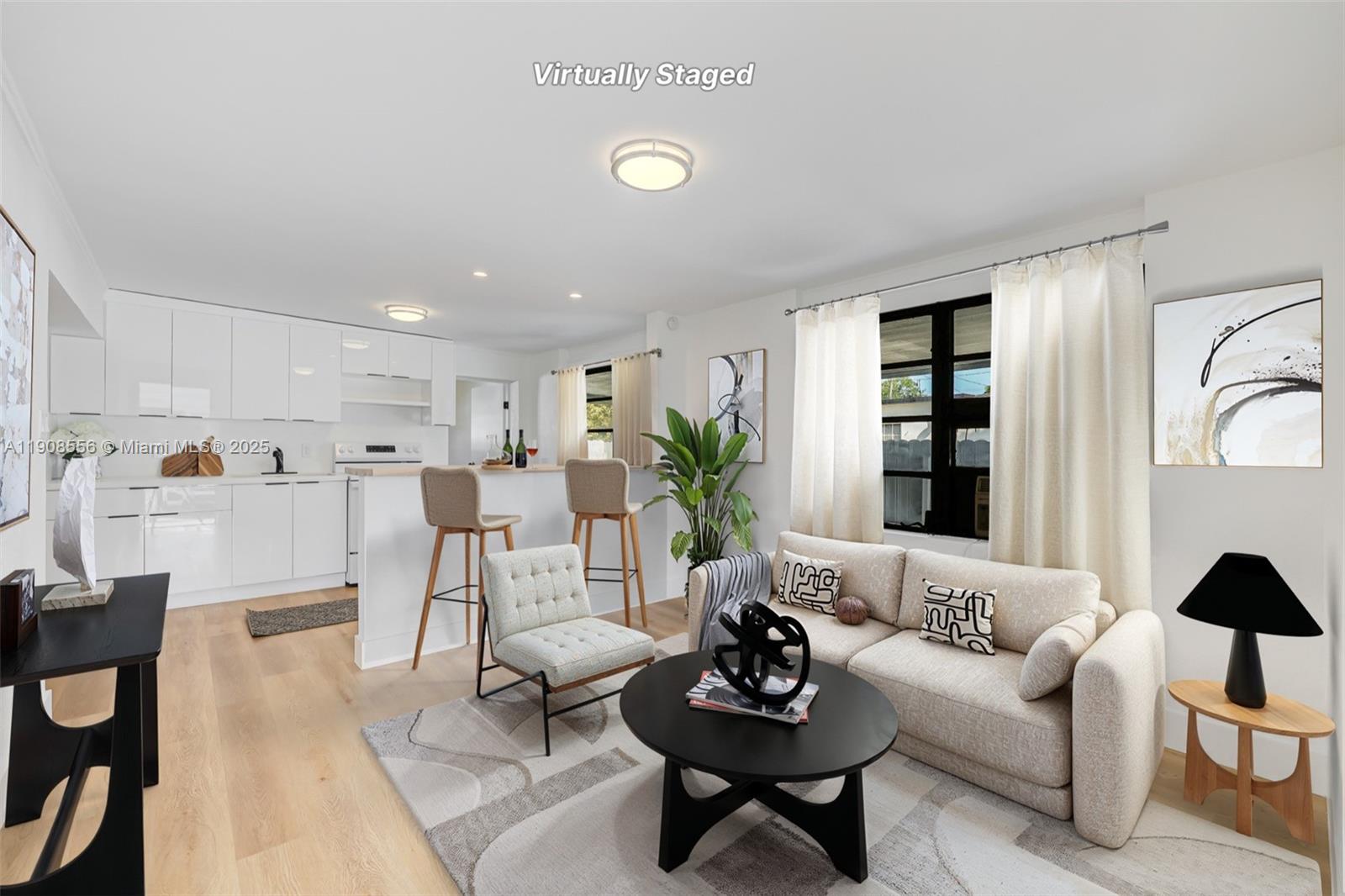 a living room with furniture kitchen view and a window