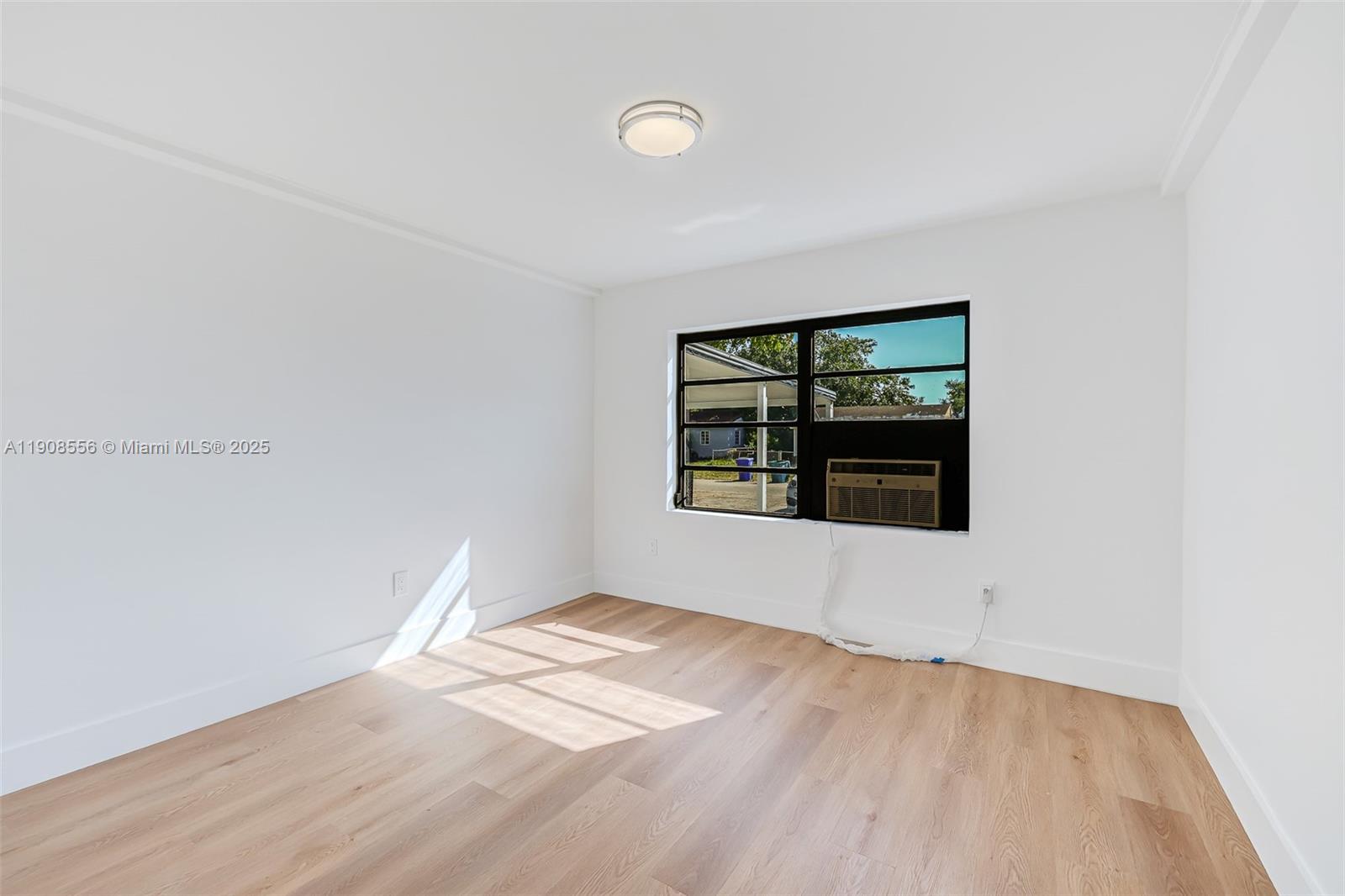 Grapeland Heights Estates Miami, FL 33125 - Photo 12 of 26 an empty room with wooden floor and windows