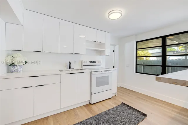 a kitchen with stainless steel appliances granite countertop a sink and cabinets with wooden floor