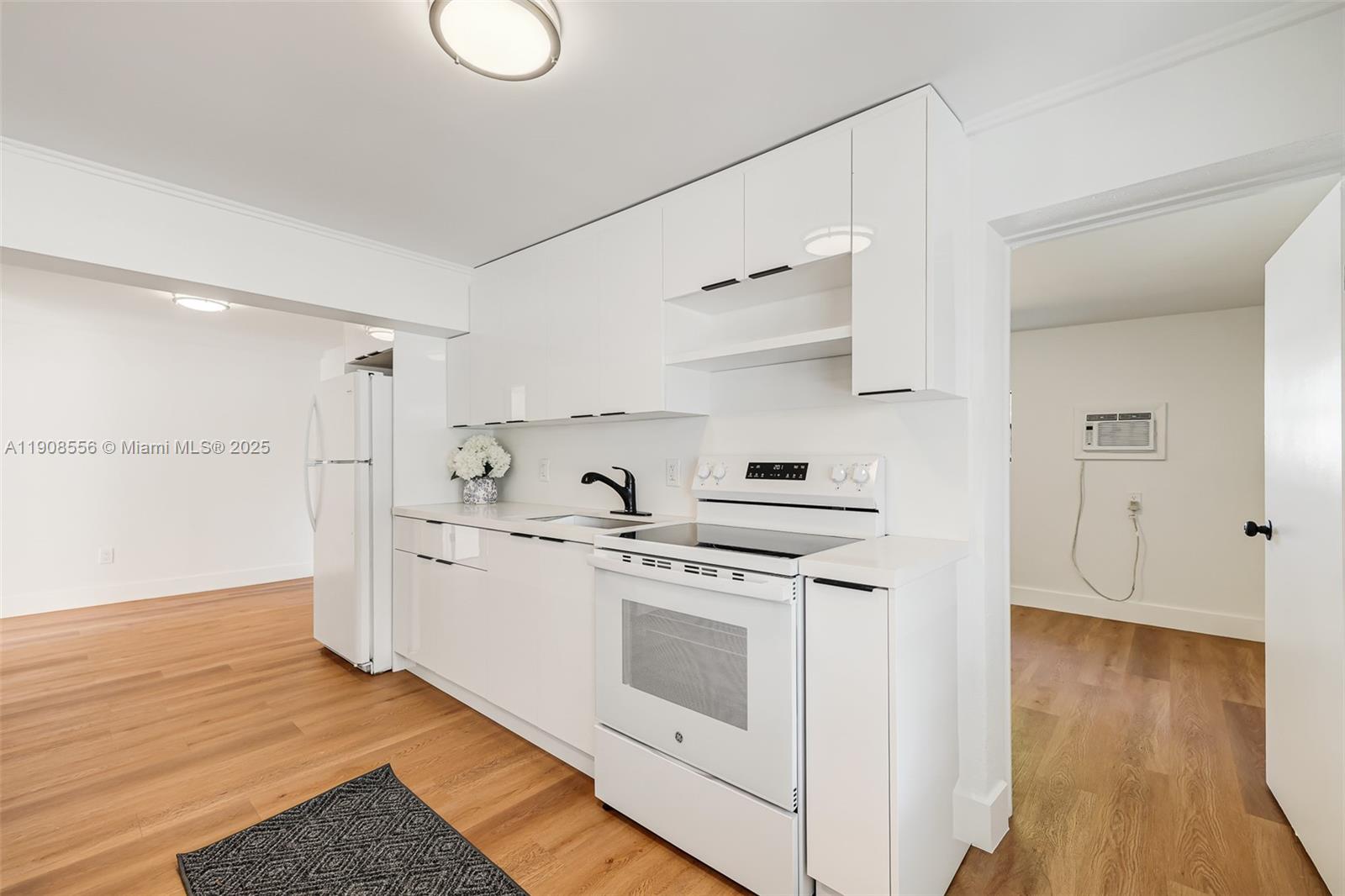 Grapeland Heights Estates Miami, FL 33125 - Photo 7 of 26 a kitchen with stainless steel appliances granite countertop a stove and white cabinets with wooden floor