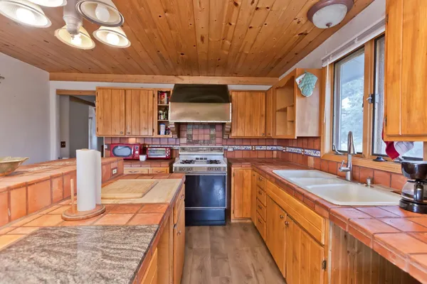 a large kitchen with stainless steel appliances granite countertop a sink stove and cabinets