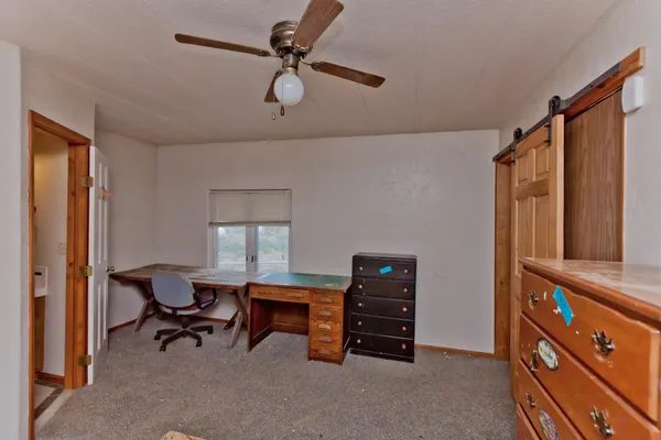 a view of a workspace with furniture and a window