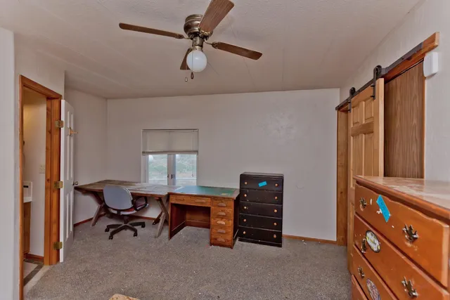 a view of a workspace with furniture and a window