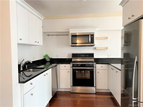 a kitchen with stainless steel appliances a stove microwave and a refrigerator
