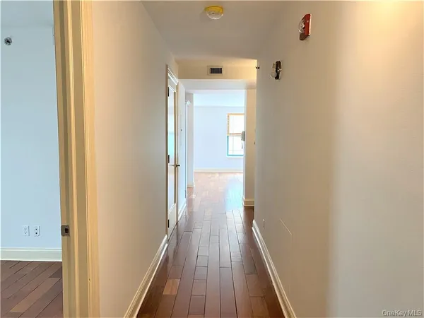 a view of a hallway with wooden floor