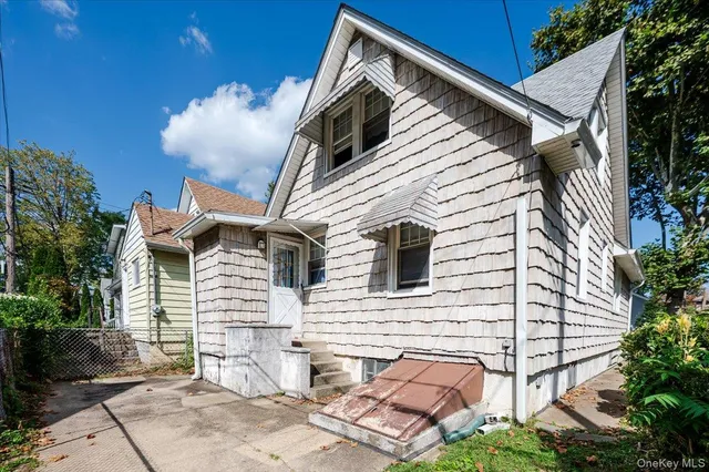 a view of house with a yard and potted plants