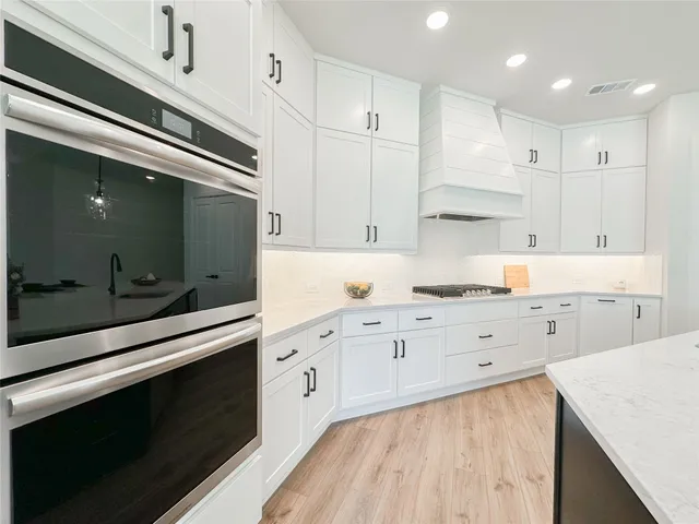 a kitchen with granite countertop white cabinets white stainless steel appliances and sink