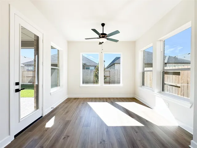 a view of an empty room with a window and wooden floor