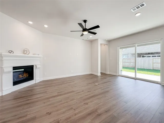 a view of an empty room with a fireplace and a window