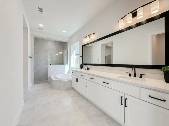 a large white bathroom with a double vanity sink a mirror and a toilet
