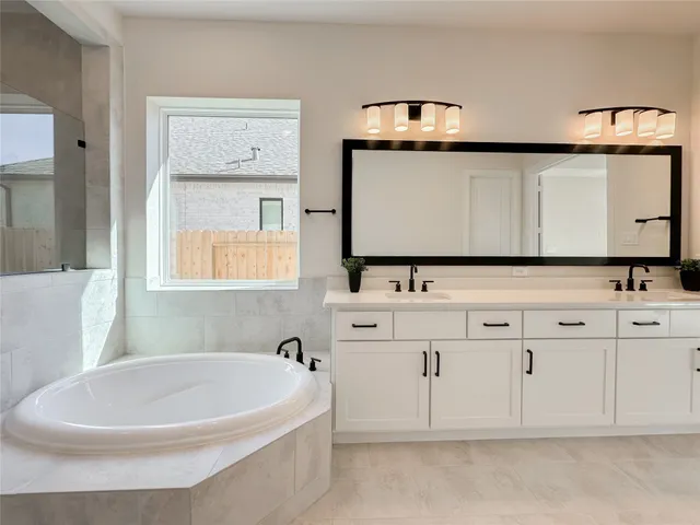 a bathroom with a bathtub a sink and a mirror