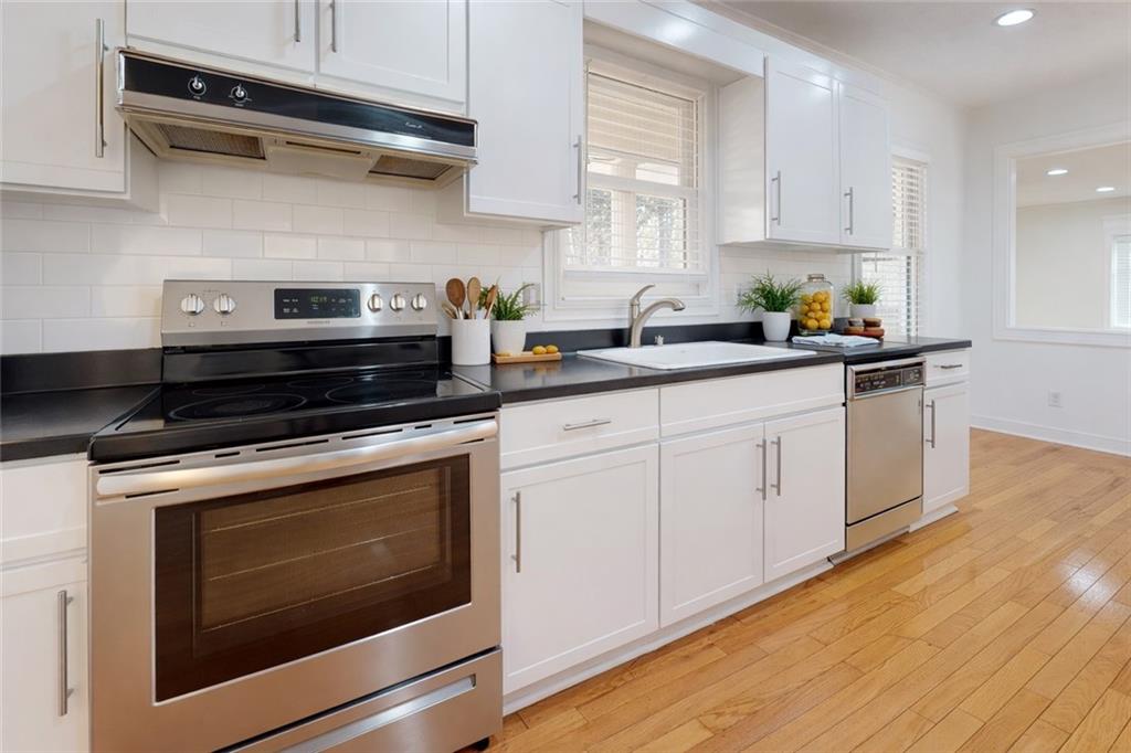 1319 Janmar Road Snellville, GA 30078 - Photo 4 of 38 a kitchen with cabinets stainless steel appliances and wooden floor