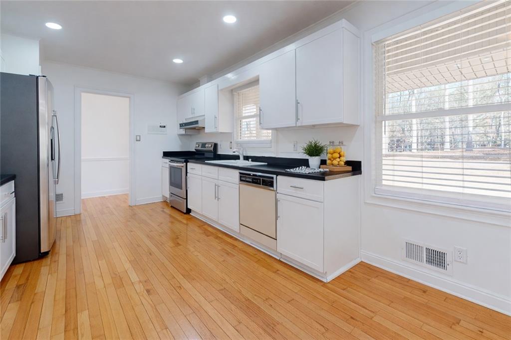 1319 Janmar Road Snellville, GA 30078 - Photo 5 of 38 a kitchen with stainless steel appliances granite countertop a stove a sink and a refrigerator