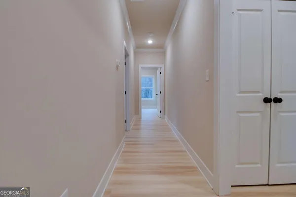 a view of a hallway with wooden floor and staircase