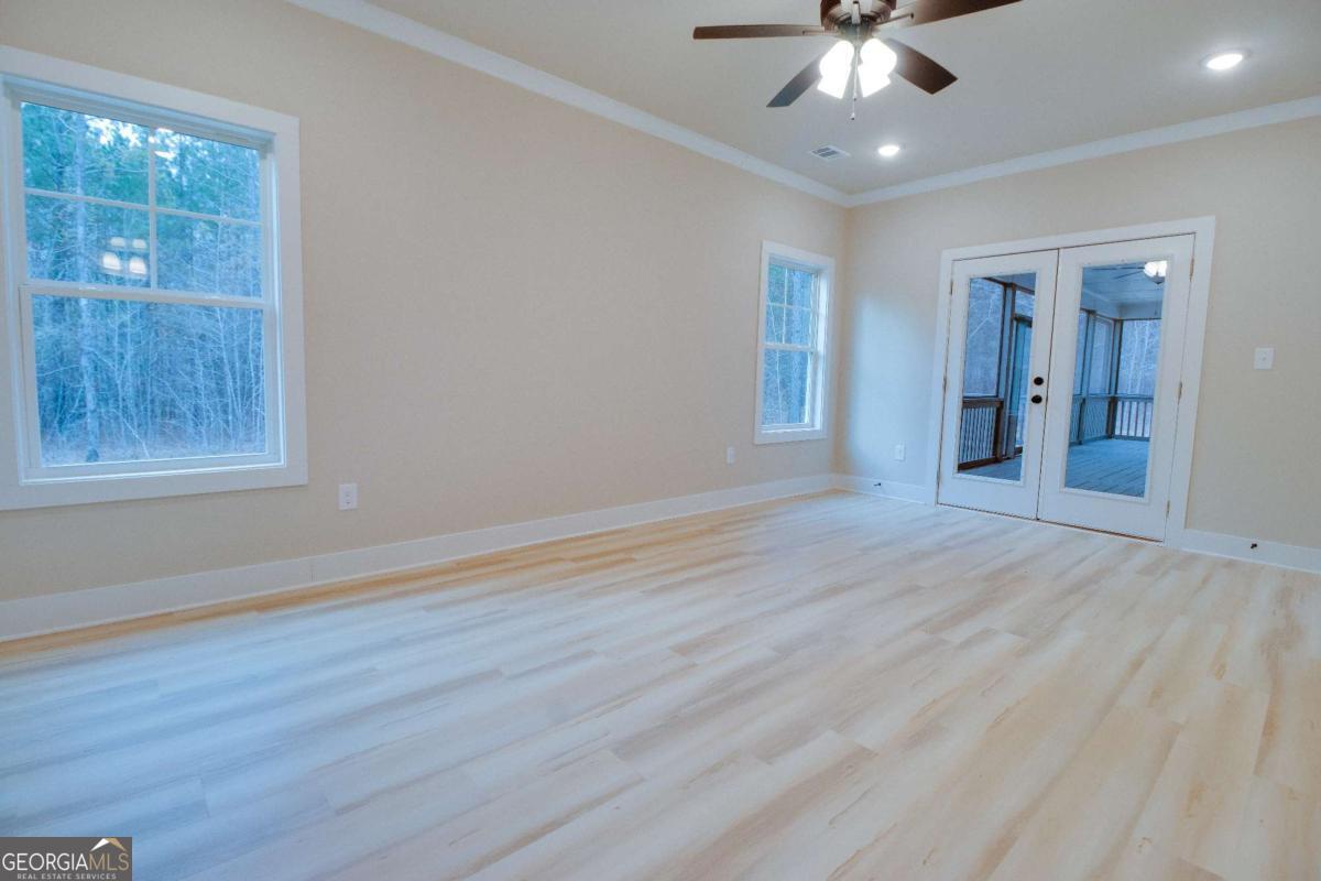 1021 Pointe Street South Tignall, GA 30668 - Photo 18 of 48 a view of an empty room with wooden floor and a window