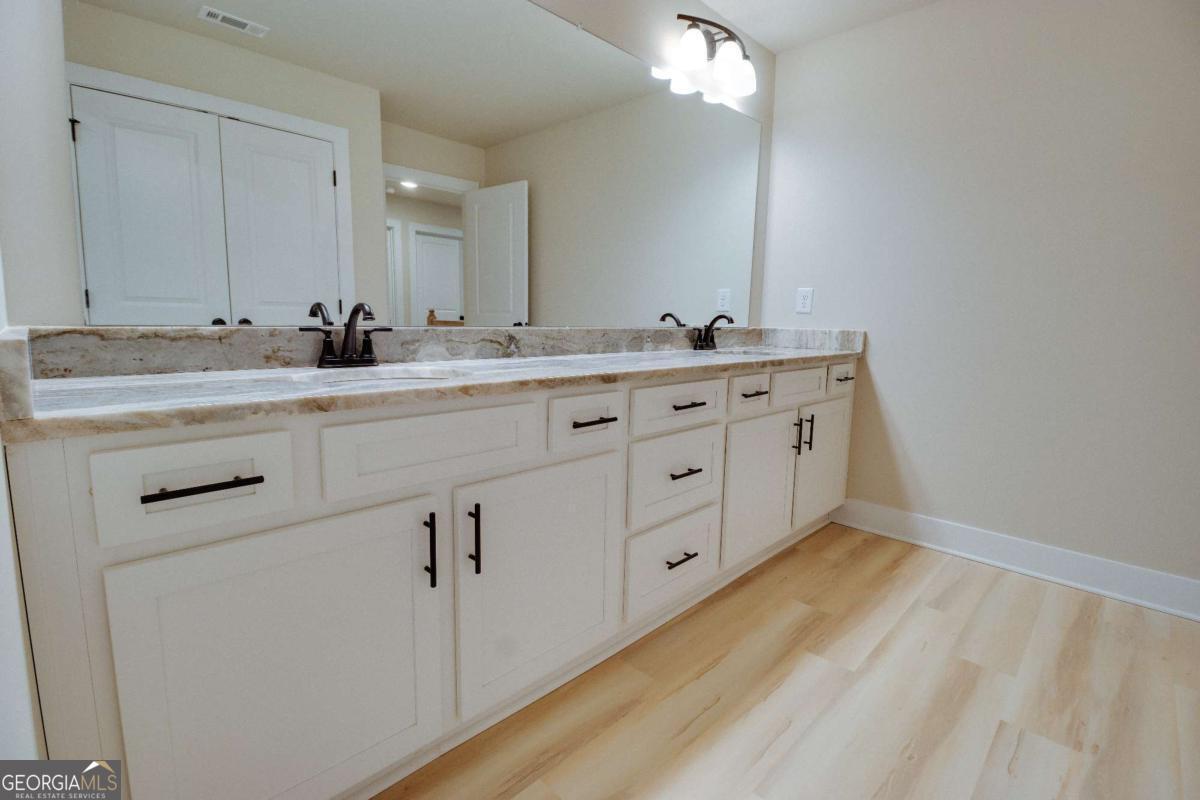 1021 Pointe Street South Tignall, GA 30668 - Photo 19 of 48 a bathroom with a double vanity sink and mirror