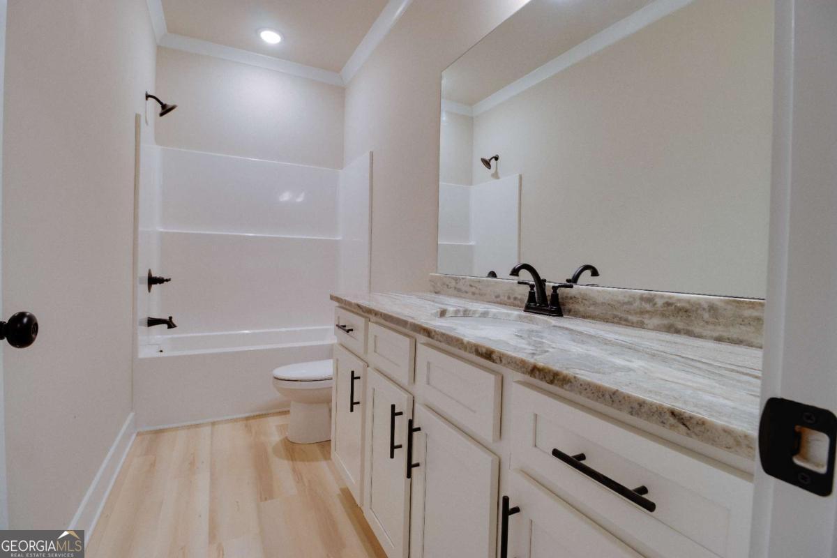 1021 Pointe Street South Tignall, GA 30668 - Photo 25 of 48 a bathroom with a double vanity sink toilet mirror and bathtub