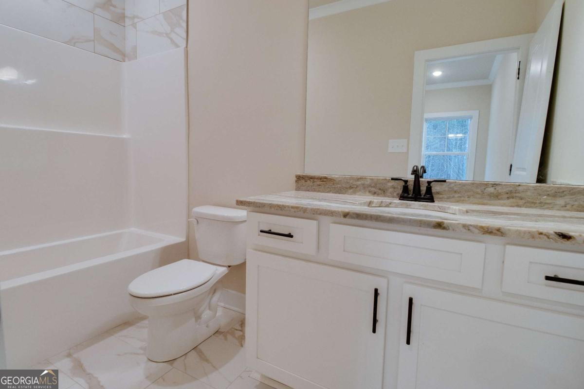 1021 Pointe Street South Tignall, GA 30668 - Photo 26 of 48 a bathroom with a sink toilet vanity and tub