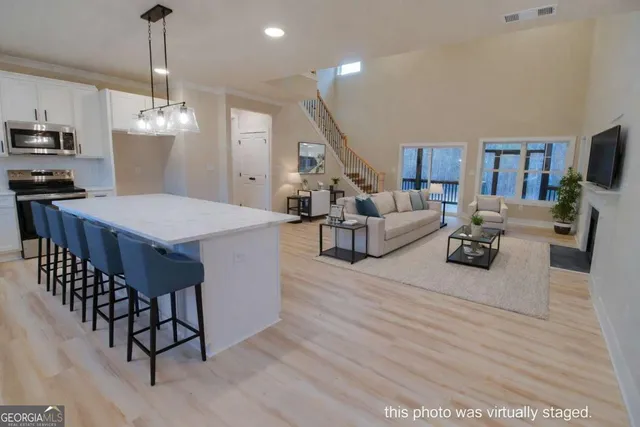 a living room with furniture a dining table and a chandelier