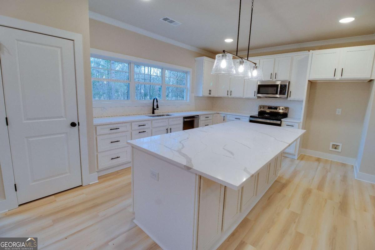 1021 Pointe Street South Tignall, GA 30668 - Photo 8 of 48 a kitchen with granite countertop a sink cabinets a counter top space and stainless steel appliances