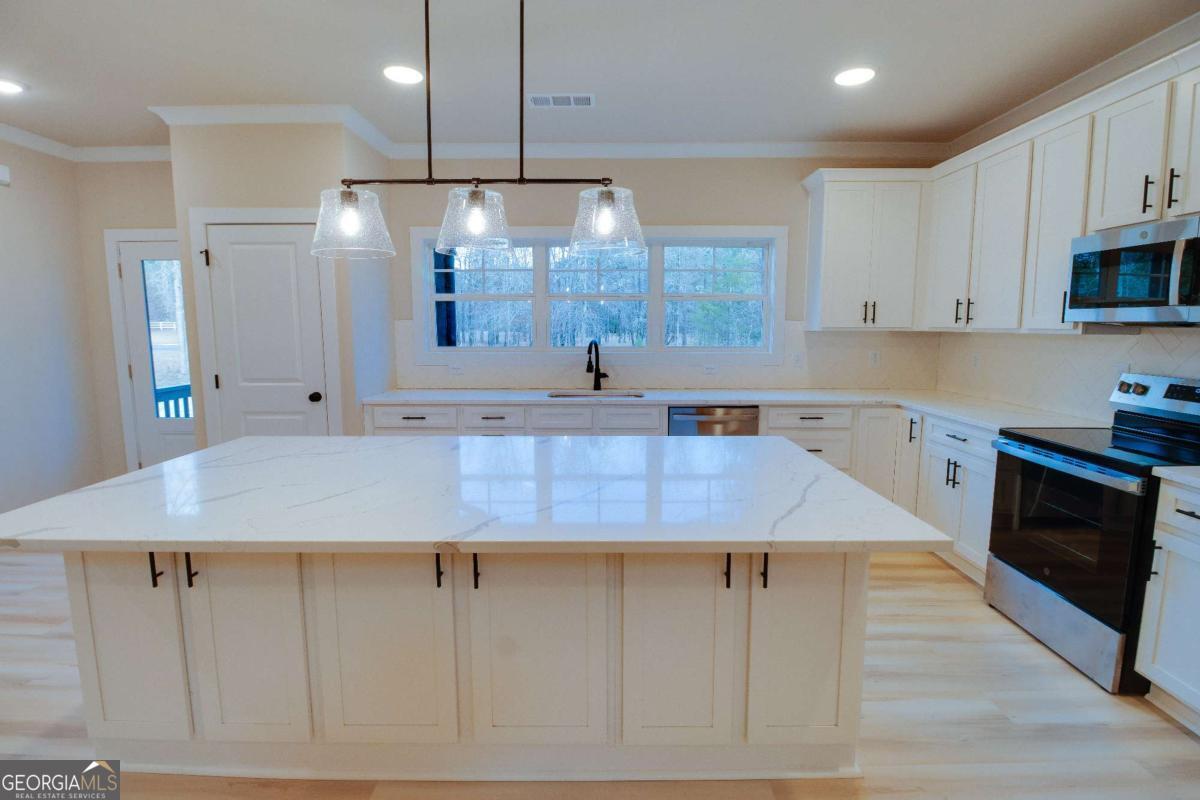 1021 Pointe Street South Tignall, GA 30668 - Photo 10 of 48 a view of a kitchen with kitchen island a sink stainless steel appliances and cabinets