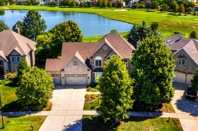 a aerial view of a house with a garden and lake view