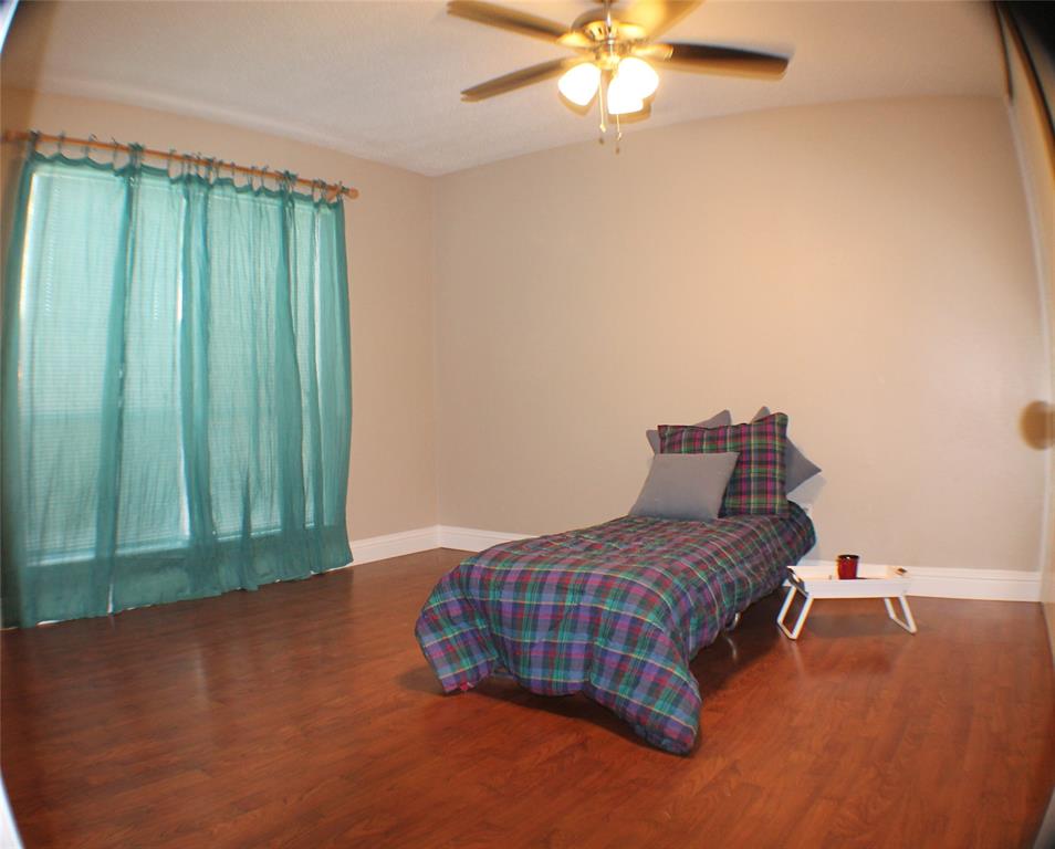 722 Intrepid Drive Garland, TX 75043 - Photo 11 of 19 a bedroom with a bed and a chandelier