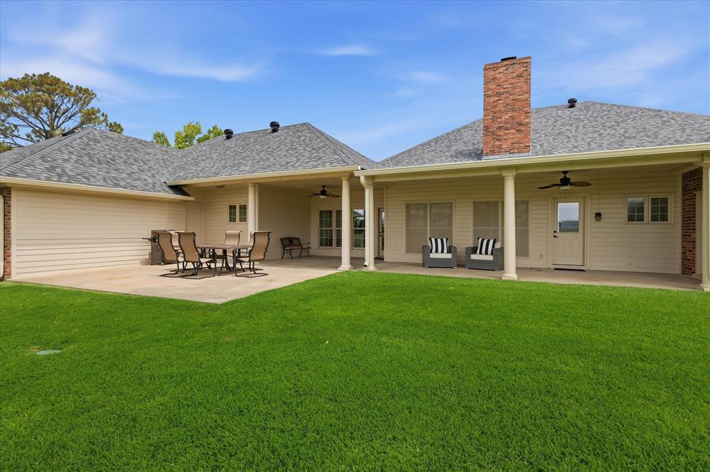 6955 Hawk Road Flower Mound, TX 75022 - Photo 32 of 40 Expansive backyard featuring a manicured lawn, a large concrete patio, and a covered porch area