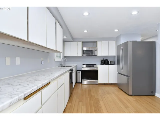 a kitchen with stainless steel appliances granite countertop a refrigerator sink and cabinets