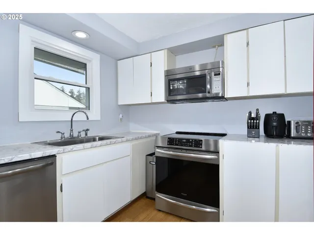 a kitchen with stainless steel appliances granite countertop a sink stove and microwave