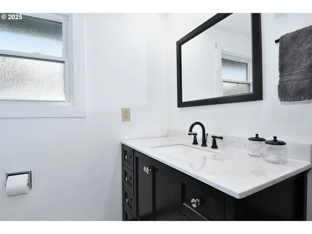 a bathroom with a sink vanity and a mirror