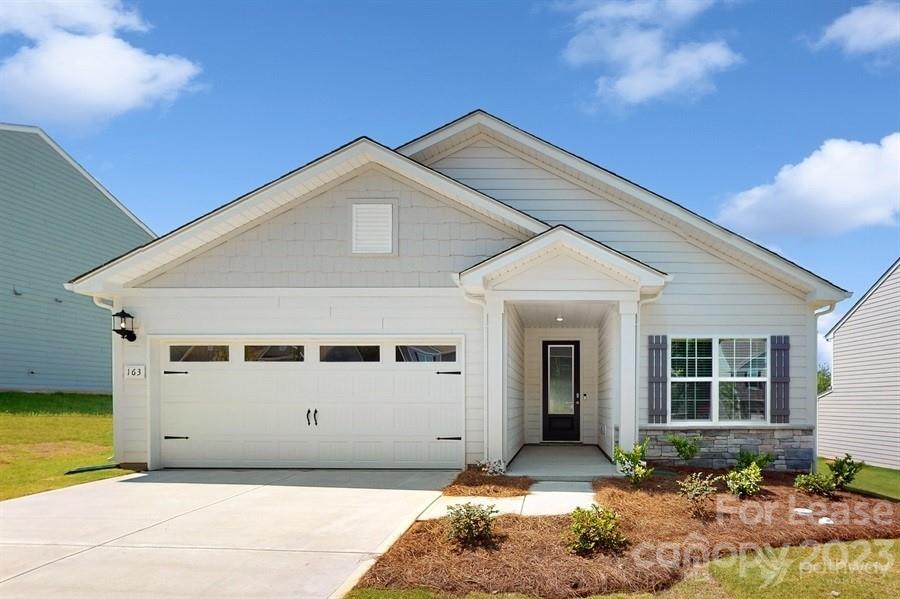 163 Tanner Loop Troutman, NC 28166 - Photo 1 of 27 a front view of a house with garden