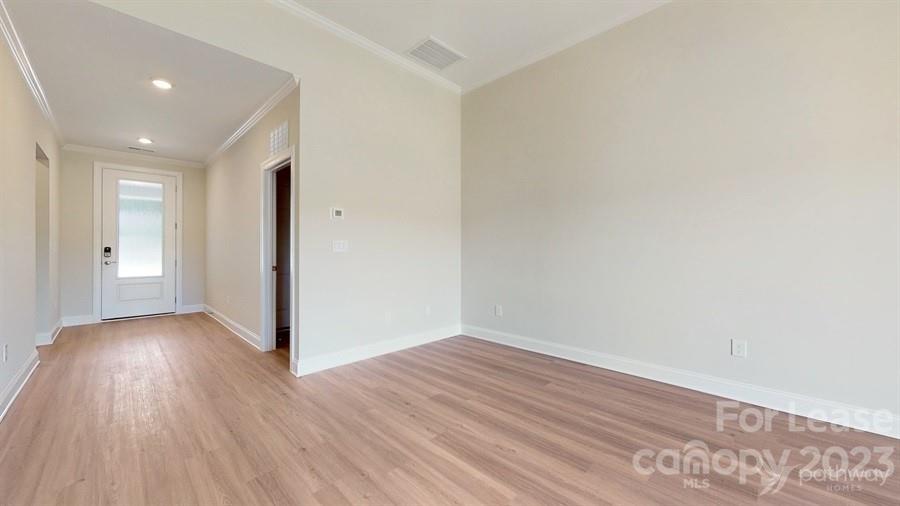 163 Tanner Loop Troutman, NC 28166 - Photo 5 of 27 wooden floor in an empty room with a window