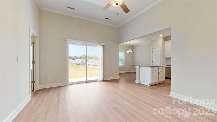 163 Tanner Loop Troutman, NC 28166 - Photo 6 of 27 an empty room with wooden floor and windows