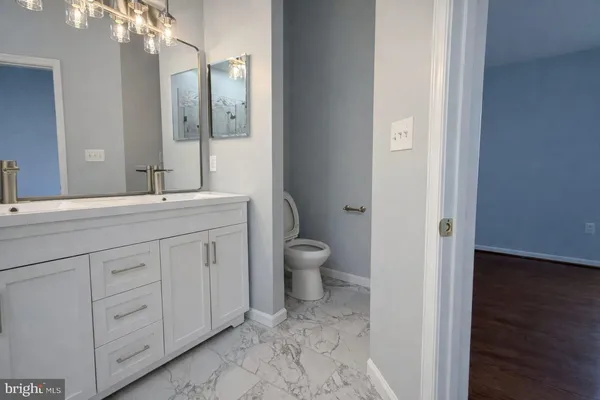 a bathroom with a toilet a sink and mirror