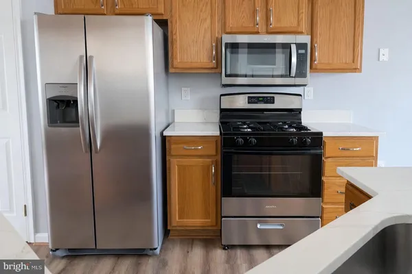 a kitchen with stainless steel appliances granite countertop a refrigerator and a stove