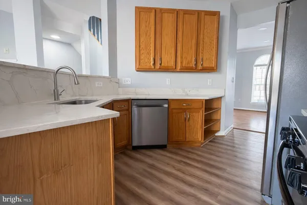 a kitchen with stainless steel appliances a sink cabinets and wooden floor