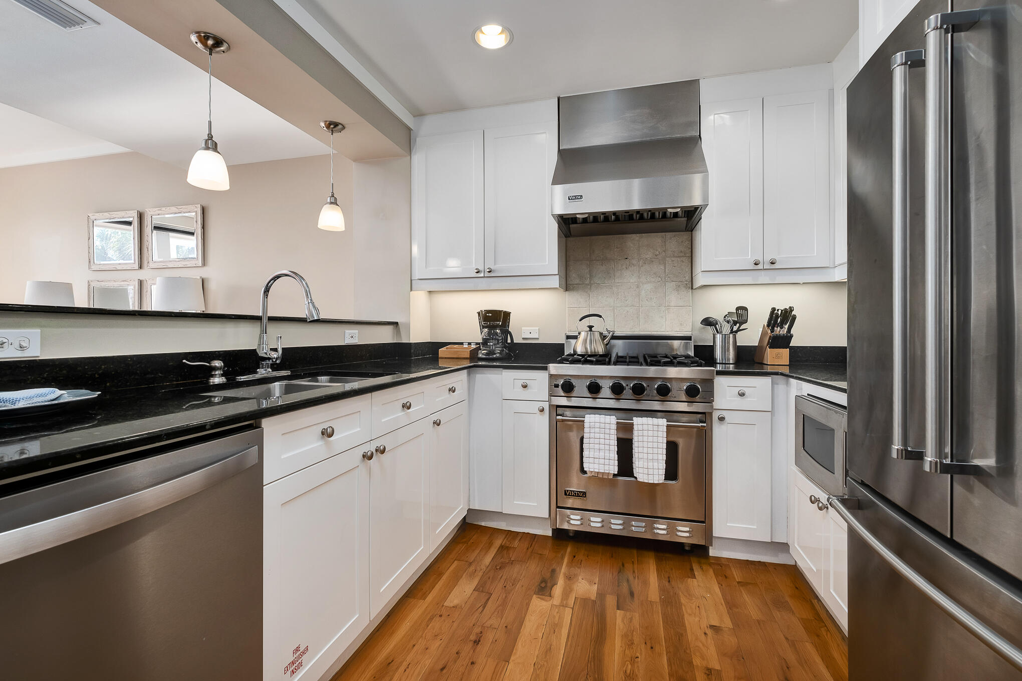 337 Bridge Lane, Unit 103B Inlet Beach, FL 32461 - Photo 10 of 37 a kitchen with stainless steel appliances a sink dishwasher a stove and white cabinets with wooden floor