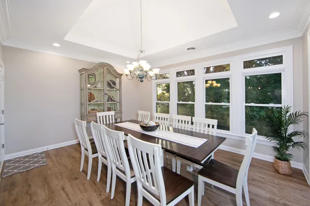a view of a dining room with furniture wooden floor and chandelier
