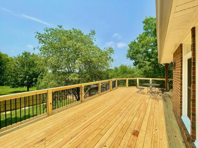 a view of a balcony with wooden floor and fence
