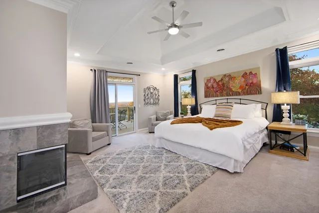 a spacious bedroom with a large bed a chandelier and windows