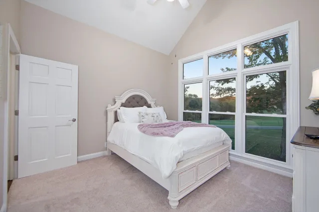 a bedroom with a bed and a large window
