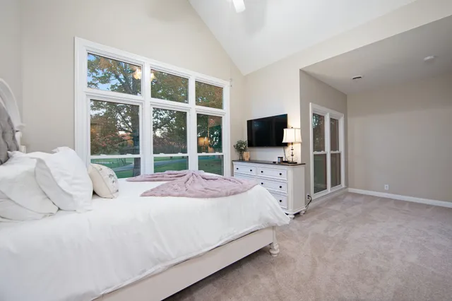 a bedroom with a bed flat screen tv and a window