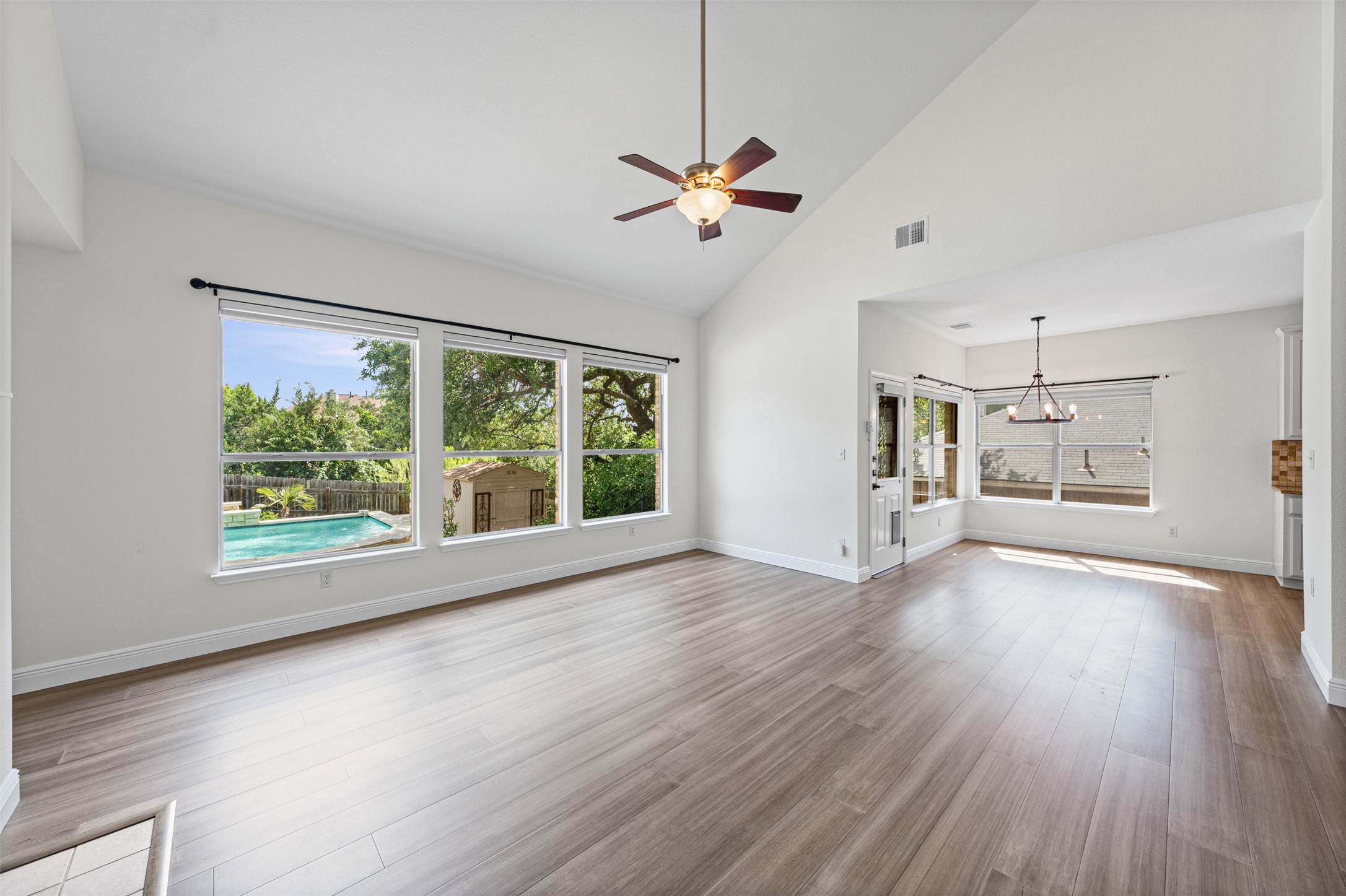 8820 Colberg Drive Austin, TX 78749 - Photo 7 of 35 A spacious living area with vast ceilings overlooks a private pool and verdant landscape.