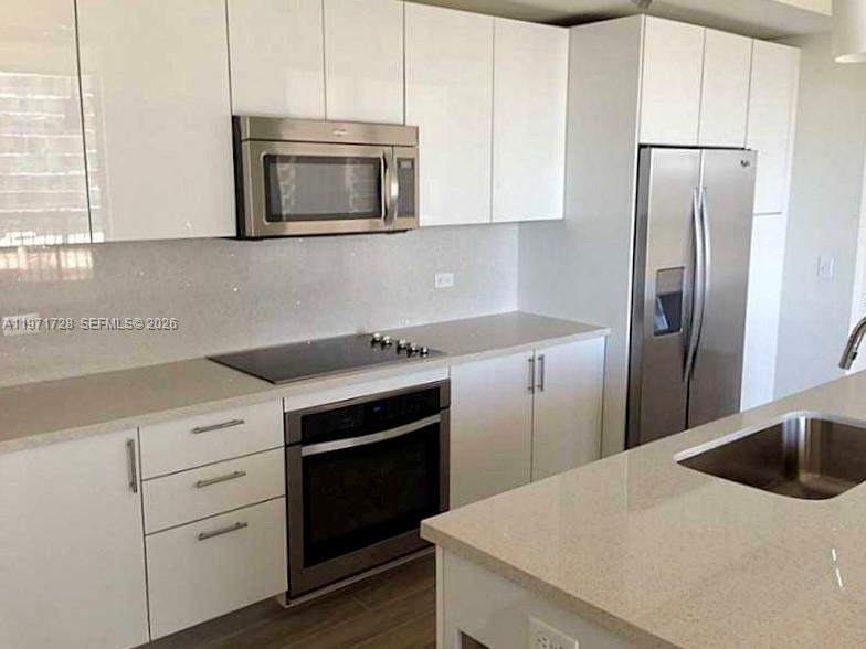 999 Southwest 1st Avenue, Unit 1803 Miami, FL 33130 - Photo 3 of 13 a kitchen with a white stove and refrigerator