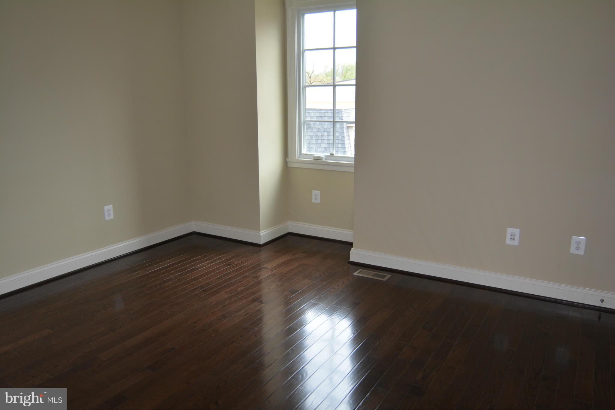 4526 Westhall Drive Washington, DC 20007 - Photo 18 of 20 an empty room with wooden floor and windows