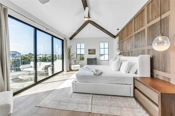 a room with stainless steel appliances kitchen island granite countertop a refrigerator a sink dishwasher a dining table and chairs with wooden floor