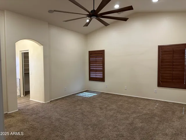 an empty room with windows and fan