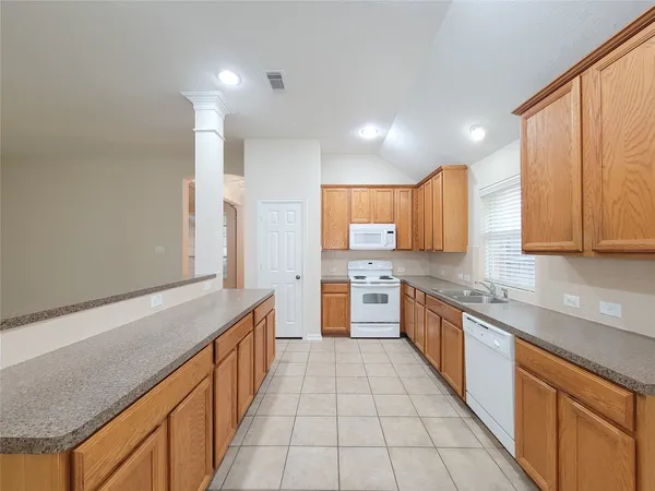 a large kitchen with stainless steel appliances granite countertop a sink and cabinets